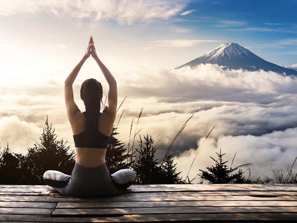 Young woman practicing yoga in the nature. female happiness. Landscape background