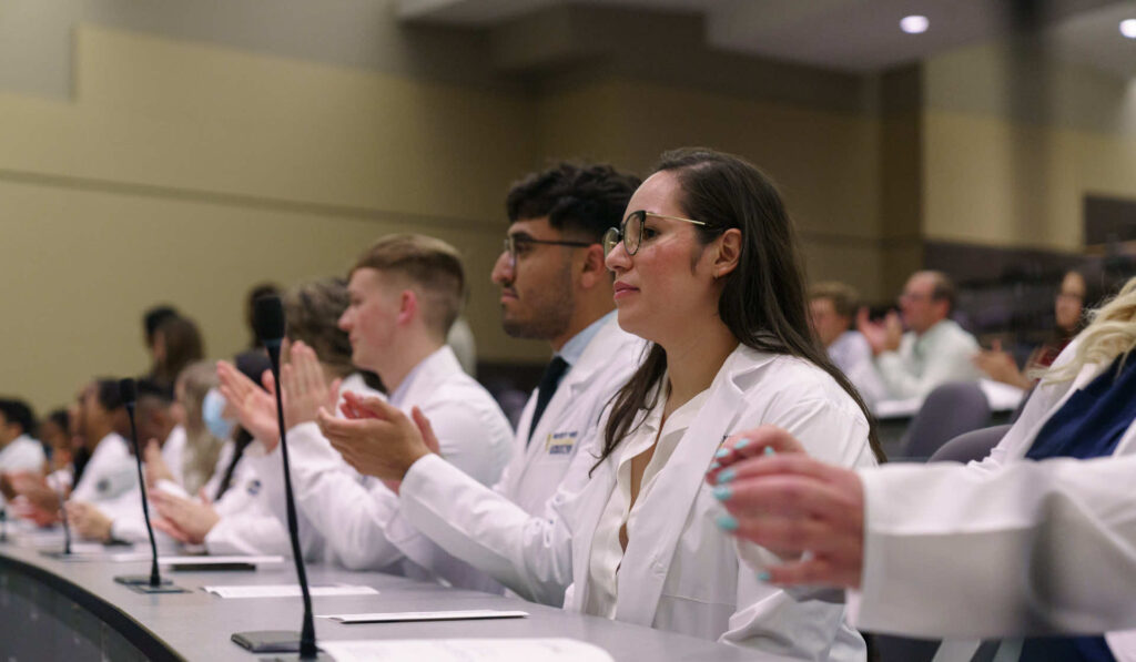 Students sitting in classroom with white coats in Colorado campus