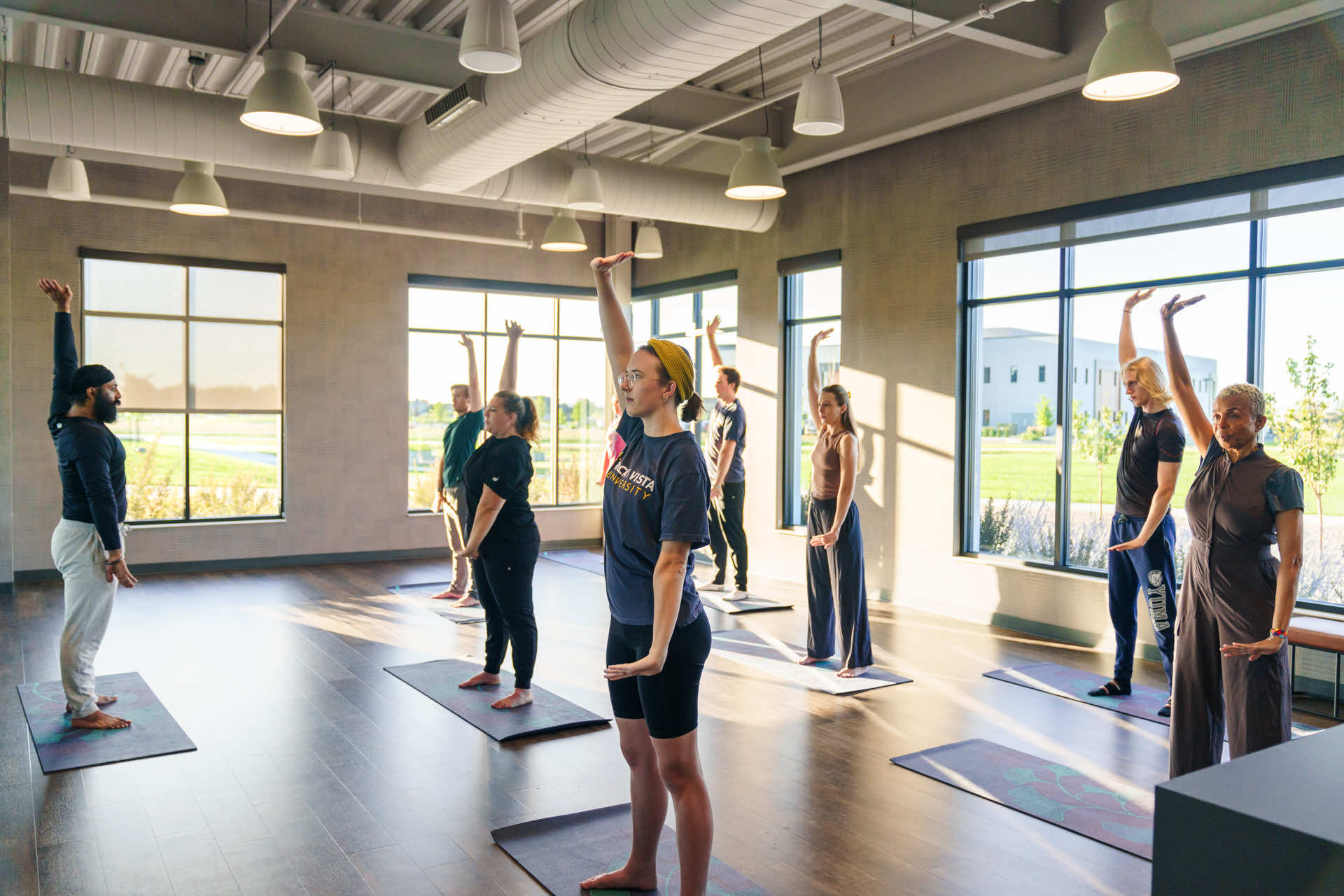 Group of people doing yoga in a studio.