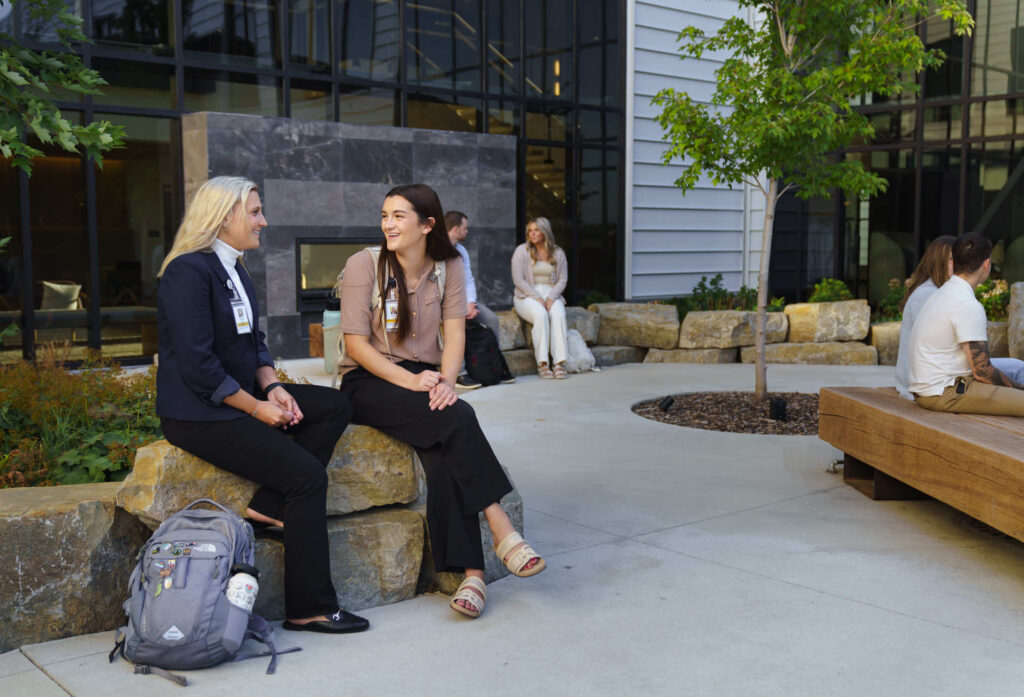 2 women sitting outdoors at the Montana campus