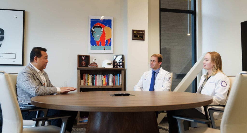 Two men and a woman sitting around a table