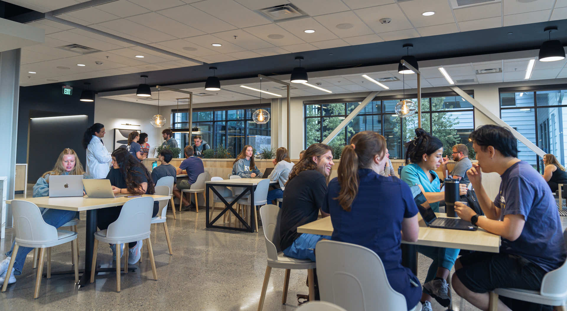 Students sitting at tables in library.