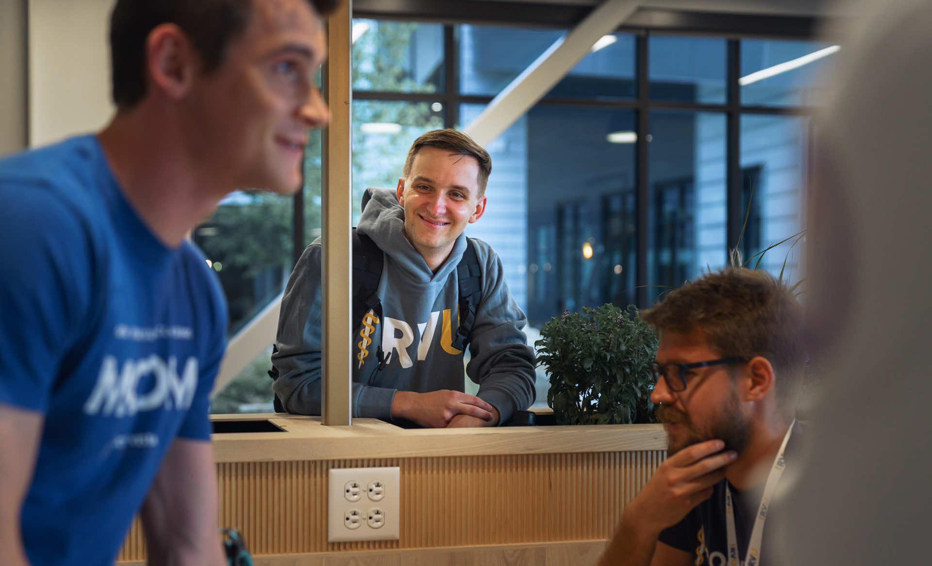 Student smiling at student behind a desk