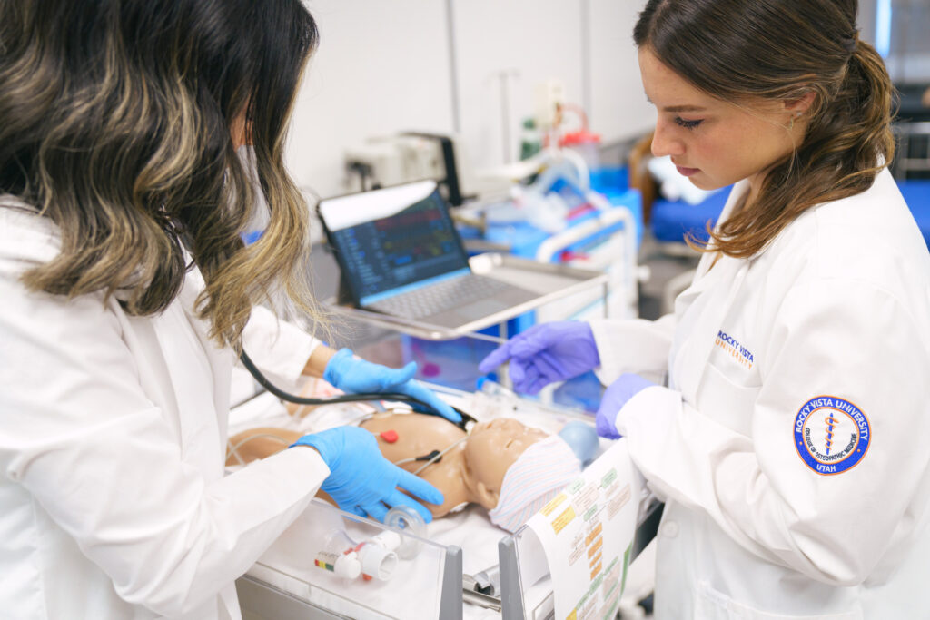 Med students working on infant doll.